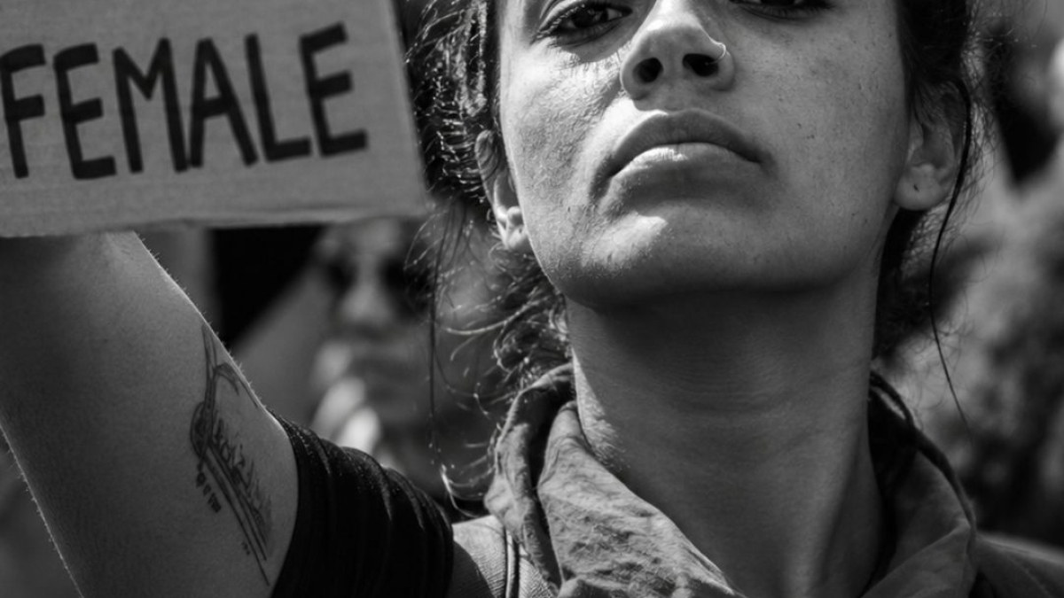 Femme déterminée en manifestation tenant une pancarte "The Future is Female" en noir et blanc, illustrant l'article sur l'hystérie comme maladie inventée pour contrôler les femmes – Hystérie Collective