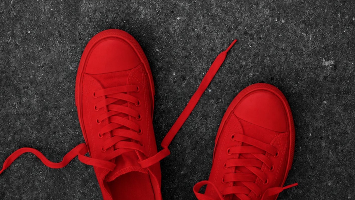 Paire de chaussures entièrement rouges sur fond gris, hommage à l'œuvre Zapatos Rojos d'Elina Chauvet contre les féminicides – Hystérie Collective