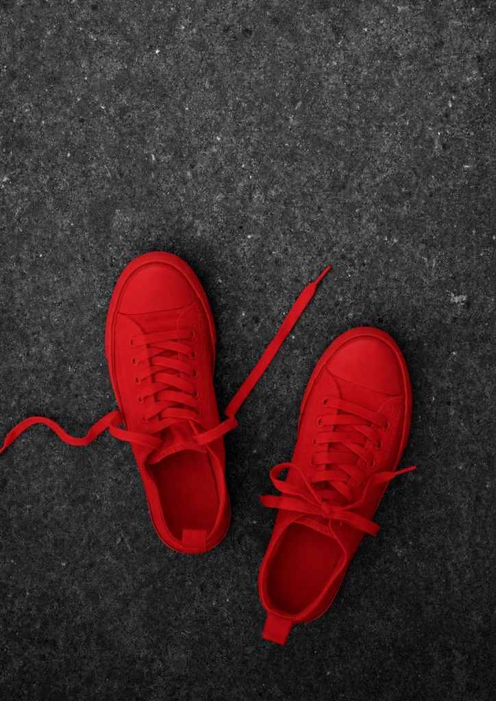Paire de chaussures entièrement rouges sur fond gris, hommage à l'œuvre Zapatos Rojos d'Elina Chauvet contre les féminicides – Hystérie Collective